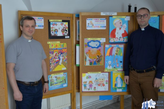 Koordynatorzy konkursów plastycznych przy wystawie konkursowej: ks. Sławomir Molendowski (z lewej) i ks. Dariusz Frydrych (z prawej). Foto: ks. S. Piekielnik / www.diecezja.radom.pl